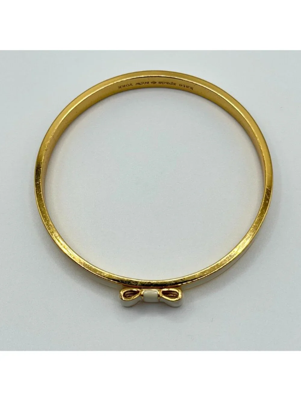 Kate Spade New York Cream Enamel Bow Gold-Tone Bangle Bracelet - Picture 2 of 4